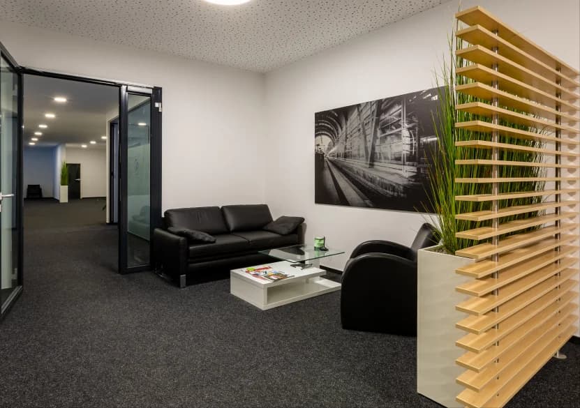 Empfangsbereich der Kanzlei bhatti.pro in Kiel mit Lounge und Wandbild